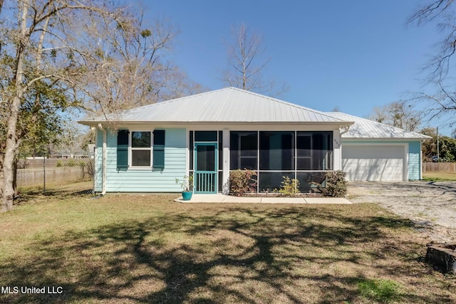 view of front facade featuring a garage, fence, a front yard, a sunroom, and metal roof