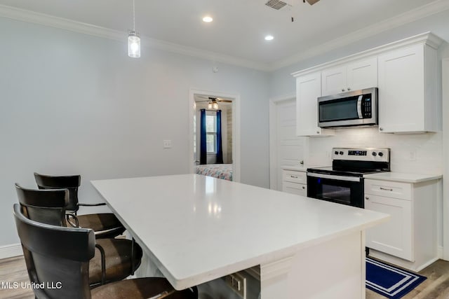 kitchen featuring tasteful backsplash, appliances with stainless steel finishes, crown molding, and light wood-style floors