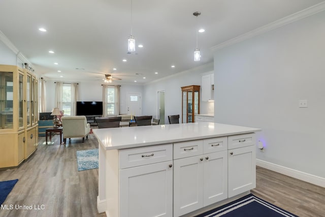 kitchen featuring light wood-type flooring, ornamental molding, recessed lighting, white cabinets, and light countertops