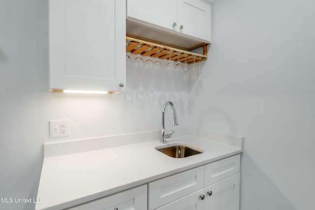 kitchen featuring a sink, white cabinetry, and light countertops