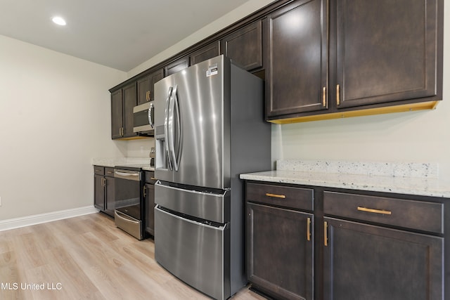 kitchen featuring light stone countertops, light hardwood / wood-style floors, stainless steel appliances, and dark brown cabinetry