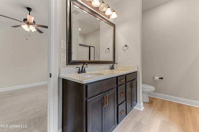 bathroom featuring a shower with door, toilet, ceiling fan, vanity, and hardwood / wood-style flooring