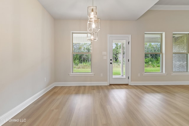 interior space featuring a wealth of natural light, crown molding, and light hardwood / wood-style floors