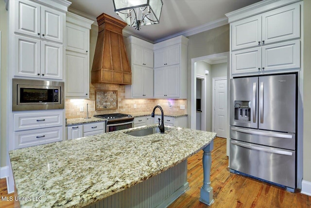 kitchen with pendant lighting, white cabinetry, premium range hood, and stainless steel appliances