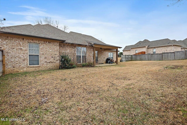 exterior space with ceiling fan and a lawn