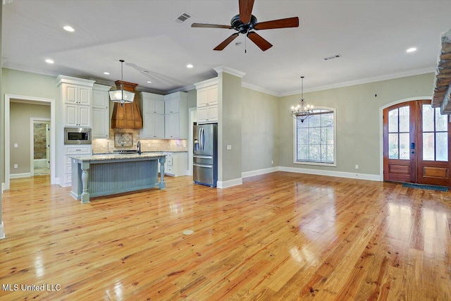 kitchen featuring a kitchen bar, appliances with stainless steel finishes, tasteful backsplash, and hanging light fixtures