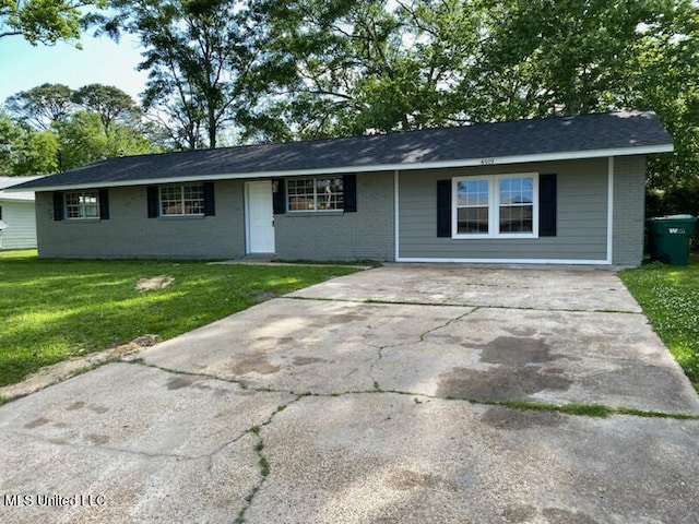 ranch-style home with brick siding, driveway, and a front lawn