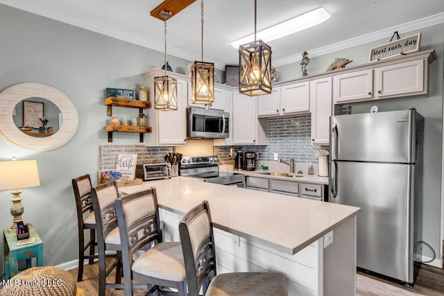 1130 Century Oaks Dr Unit B, Gulfport, MS 39507 - kitchen featuring stainless steel appliances, a kitchen breakfast bar, a peninsula, decorative backsplash, and ornamental molding