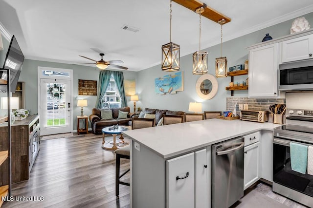 1130 Century Oaks Dr Unit B, Gulfport, MS 39507 - kitchen featuring stainless steel appliances, open shelves, a peninsula, white cabinetry, and wood finished floors