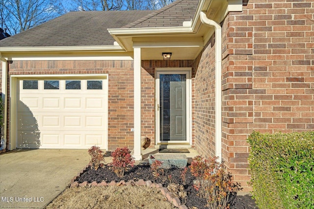 property entrance with a garage, brick siding, and roof with shingles