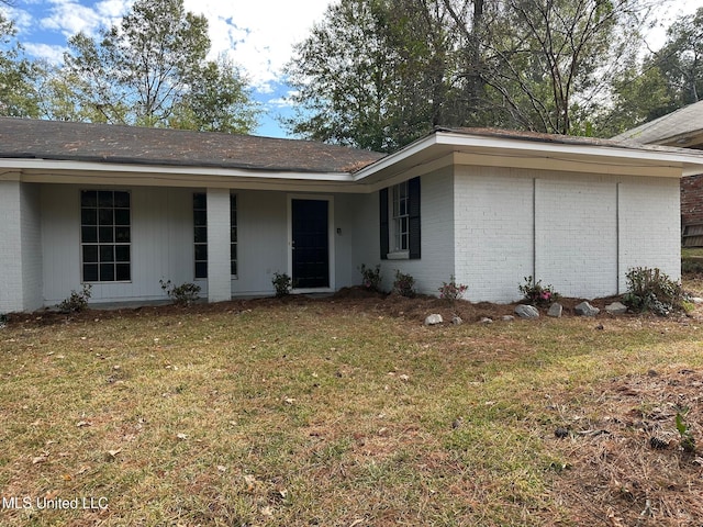 view of front of house featuring brick siding and a front yard