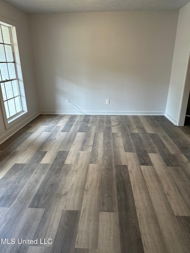spare room with dark wood-style floors and baseboards