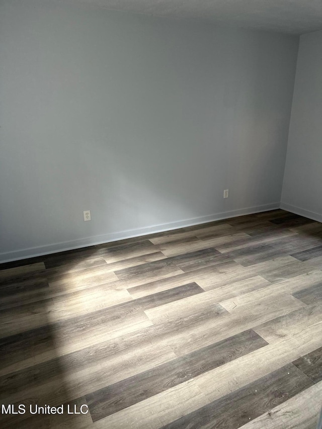 empty room with wood finished floors and baseboards