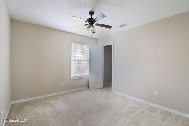 unfurnished room with baseboards, visible vents, ceiling fan, carpet, and a textured ceiling