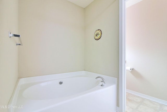 full bath with a bath and baseboards