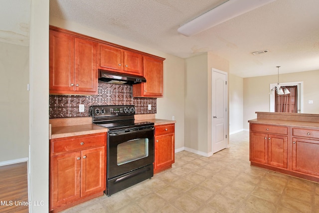 kitchen featuring light floors, light countertops, black electric range oven, decorative backsplash, and under cabinet range hood