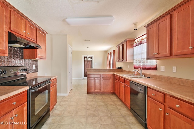 kitchen with brown cabinets, a sink, a peninsula, under cabinet range hood, and black appliances