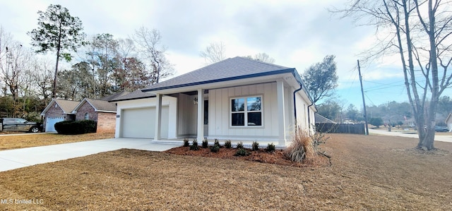 view of front of property featuring a garage, a front yard, and covered porch