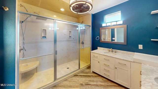 bathroom with vanity, a shower with shower door, and wood-type flooring