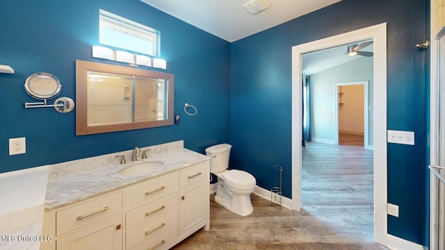 bathroom with lofted ceiling, hardwood / wood-style flooring, vanity, walk in shower, and toilet