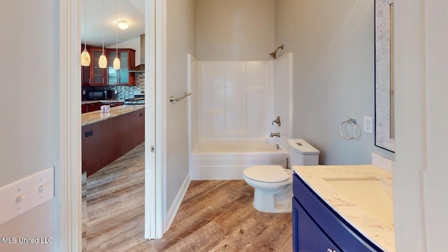 full bathroom featuring toilet, shower / tub combination, vanity, hardwood / wood-style floors, and decorative backsplash