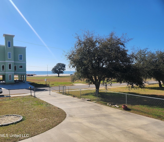 view of property's community with a water view and a lawn