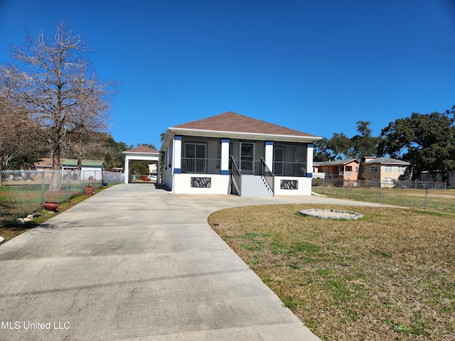 view of front of property with a carport, a sunroom, and a front yard