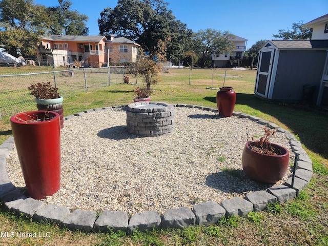 view of yard featuring a storage shed and a fire pit