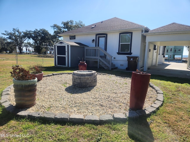 back of property with a storage shed and a fire pit