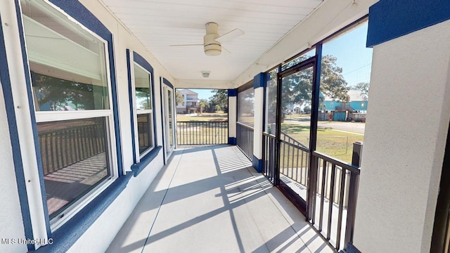 unfurnished sunroom featuring ceiling fan