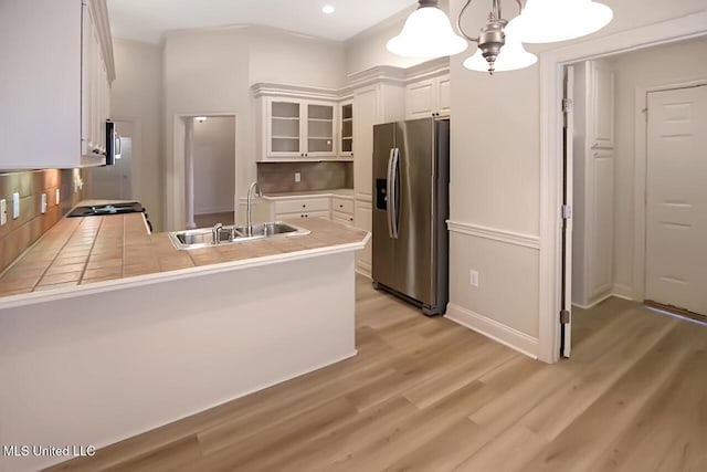 503 W Abbey Pl, Brandon, MS 39047 - kitchen featuring appliances with stainless steel finishes, a peninsula, glass insert cabinets, white cabinetry, and light wood-style flooring