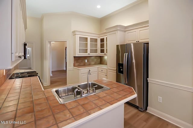 503 W Abbey Pl, Brandon, MS 39047 - kitchen with stainless steel refrigerator with ice dispenser, a peninsula, tile counters, glass insert cabinets, and tasteful backsplash
