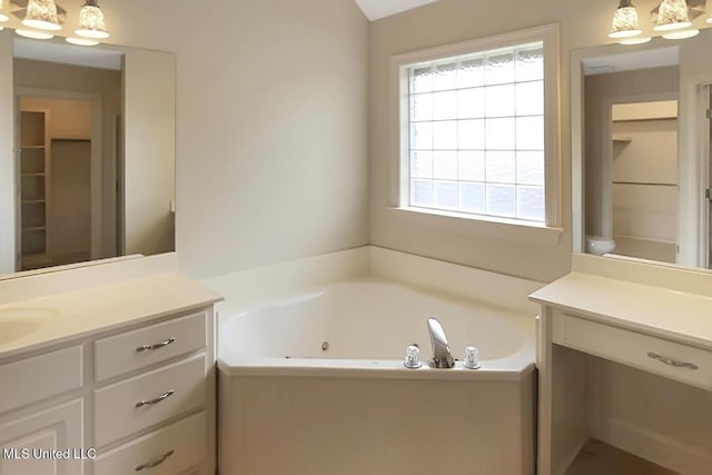 503 W Abbey Pl, Brandon, MS 39047 - bathroom with vanity, a jetted tub, a walk in closet, and a chandelier