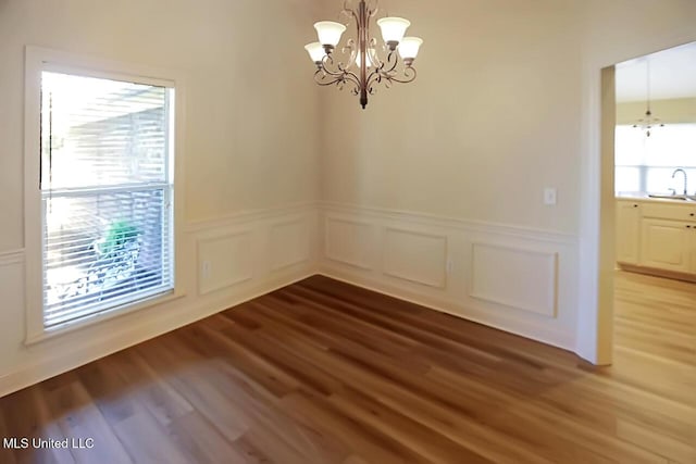 503 W Abbey Pl, Brandon, MS 39047 - unfurnished dining area with a chandelier, a wainscoted wall, wood finished floors, and a decorative wall