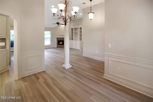 503 W Abbey Pl, Brandon, MS 39047 - unfurnished dining area with a chandelier, light wood-style floors, and a lit fireplace