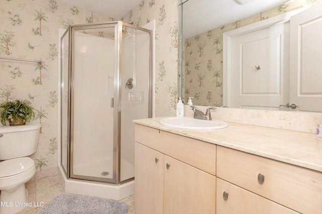 bathroom featuring tile patterned flooring, vanity, toilet, and walk in shower