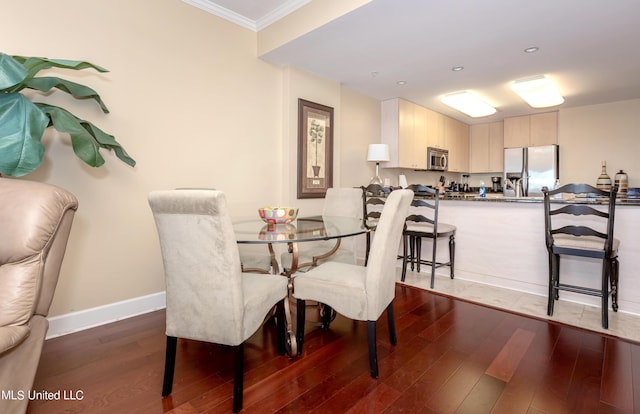 dining room with crown molding and dark wood-type flooring