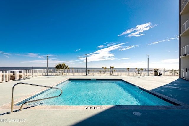 view of pool featuring a patio area and a water view