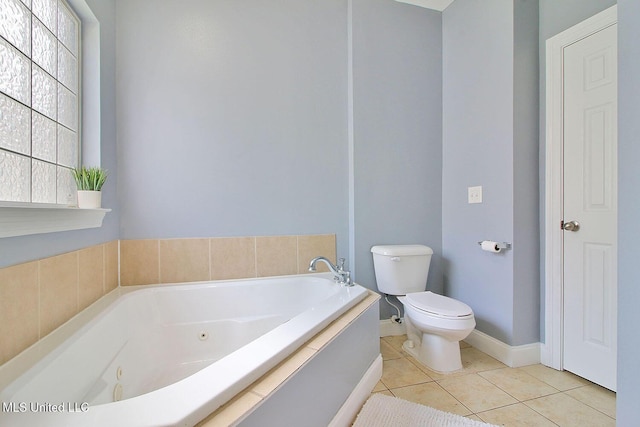 full bathroom featuring tile patterned flooring, a jetted tub, toilet, and baseboards