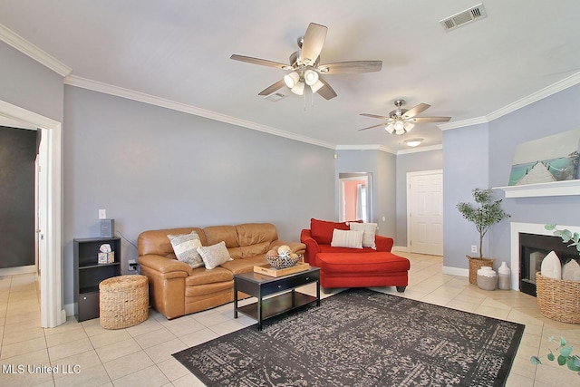 living area featuring baseboards, visible vents, a fireplace, ornamental molding, and tile patterned floors