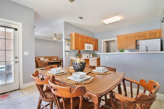 dining room with light tile patterned floors, a ceiling fan, visible vents, and baseboards