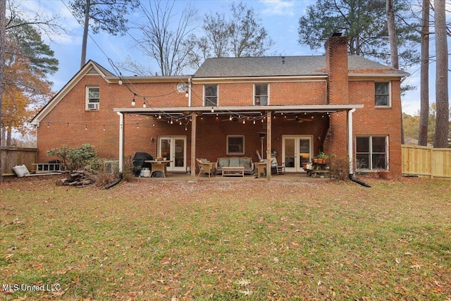 rear view of property with outdoor lounge area, a patio area, a yard, and french doors