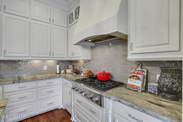 kitchen featuring white cabinetry, decorative backsplash, custom range hood, and stainless steel gas stovetop