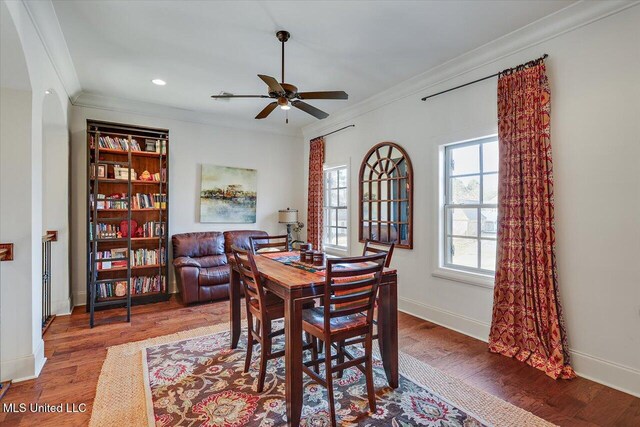 dining area featuring hardwood / wood-style floors, crown molding, and ceiling fan