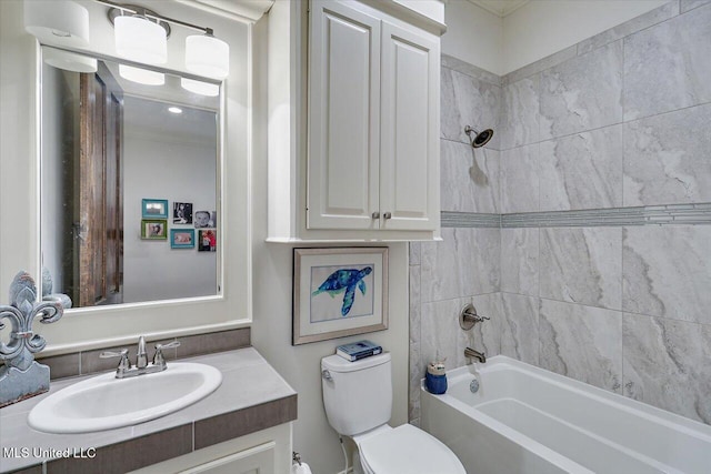 full bathroom with vanity, tiled shower / bath, and toilet