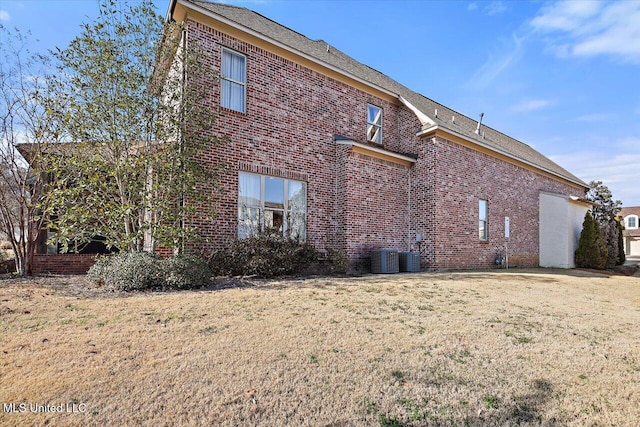 rear view of property with a yard and central AC unit