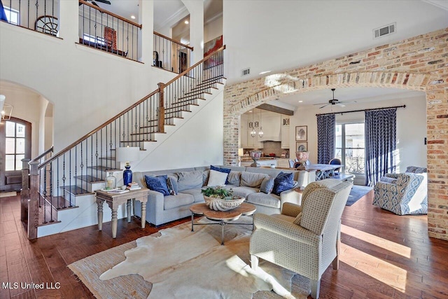 living room with ceiling fan with notable chandelier and dark hardwood / wood-style flooring