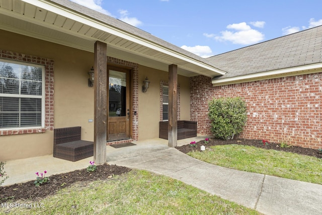 doorway to property with stucco siding and roof with shingles