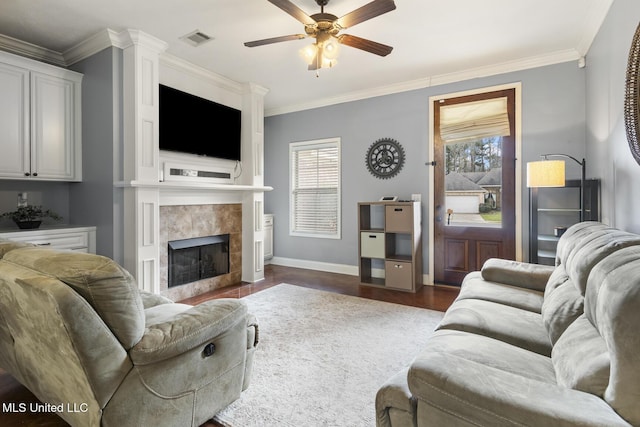 living room with a fireplace, a ceiling fan, visible vents, and ornamental molding