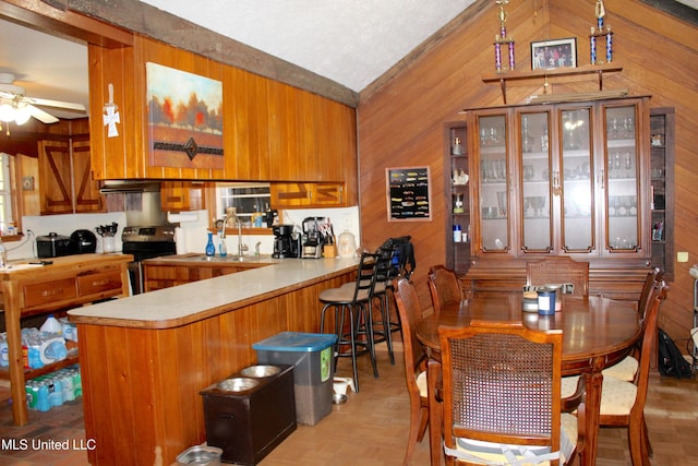 19901 Otis Cooper Rd, Moss Point, MS 39562 - dining room with wood walls, a ceiling fan, and lofted ceiling